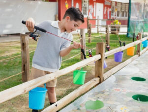 A child plays Irvine Park Railroad's Gone Fishing game with a fishing rod in hand
