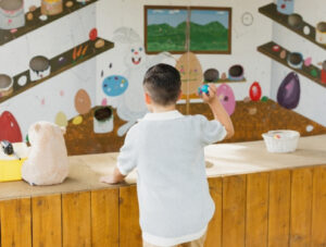 A child is throwing a pretend egg at Irvine Park Railroad's activity, Paint Party, to win a prize