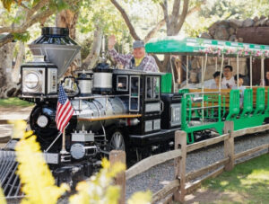Train engineer waves while driving the locomotive at Irvine Park Railroad's Easter Eggstravaganza
