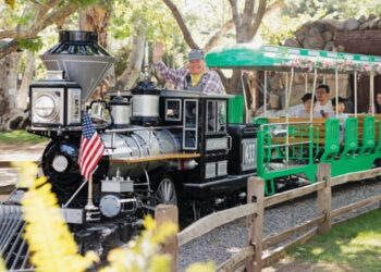 Train engineer waves while driving the locomotive at Irvine Park Railroad's Easter Eggstravaganza