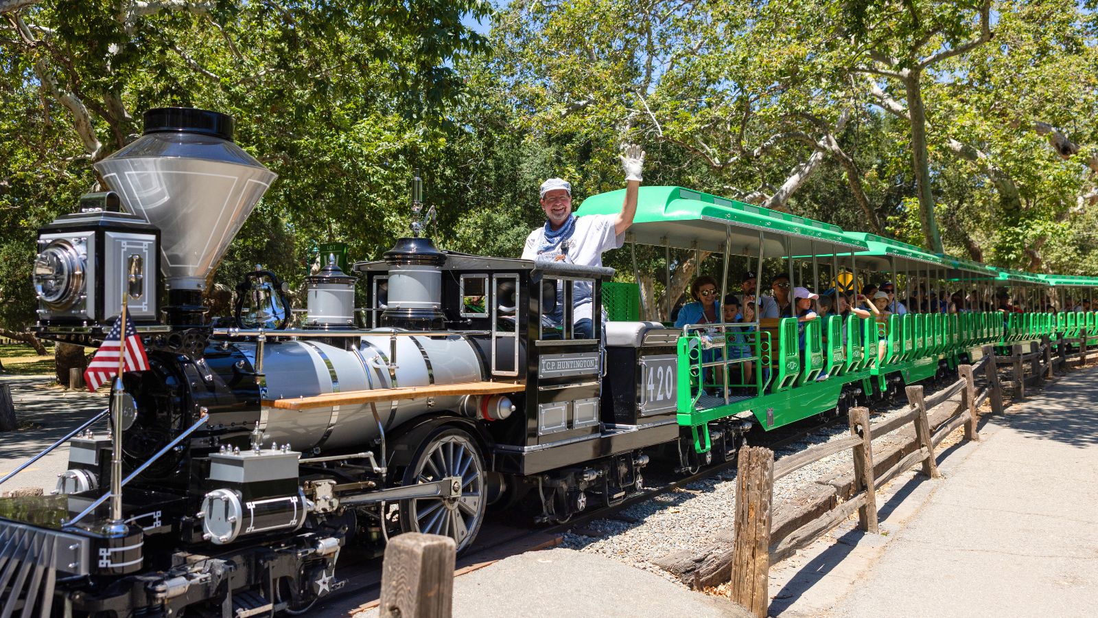 Train engineer at Irvine Park Railroad waves while aboard the train